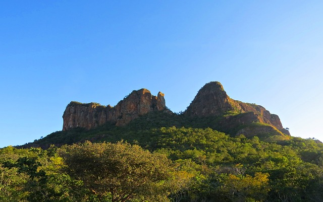 "Formações rochosas únicas do Vale da Lua, na Chapada dos Veadeiros, Goiás, cercadas pela vegetação do Cerrado e com o céu azul ao fundo."