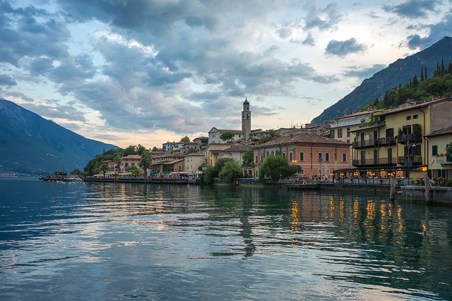 "Vista deslumbrante do Lago de Garda, com montanhas ao fundo e águas cristalinas, capturada durante o dia. A imagem mostra a beleza natural e as cidades ao redor do lago."