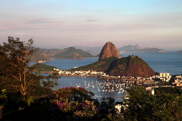 Praia de Copacabana com vista para o mar e pôr do sol no Rio de Janeiro, com pessoas aproveitando a beira da praia.